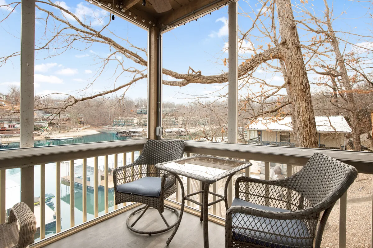An inviting outdoor seating area with wicker chairs and a small table overlooks the lake’s shimmering surface. The setting is intimate and serene, ideal for socializing, enjoying a drink, or stargazing after a night out on the Strip.